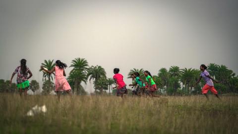 Children Playing Football in a Rural Field